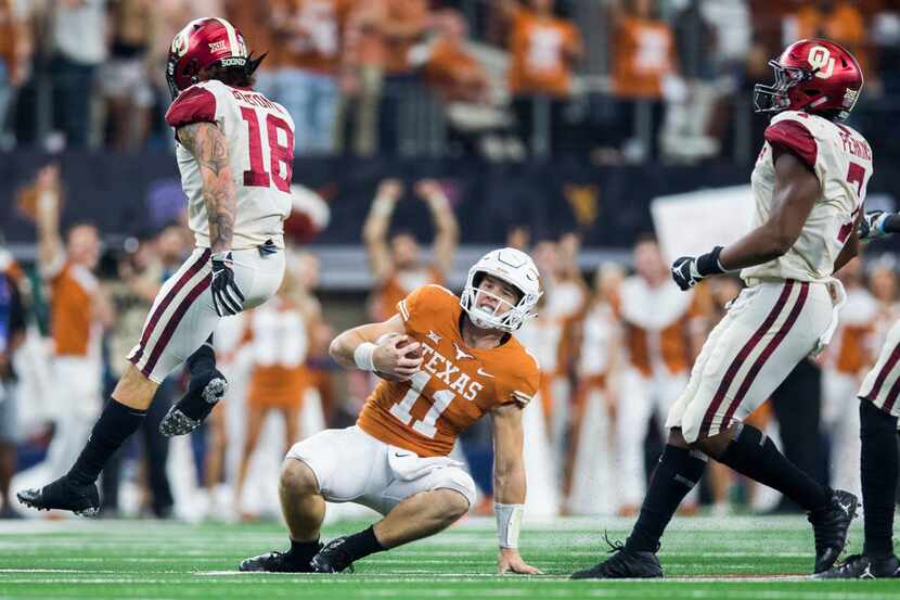 Texas Longhorns quarterback Sam Ehlinger (11) slides in to a first down during the third...