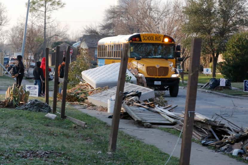 Children wait to board a GISD school bus in an area where neighborhoods were destroyed by...