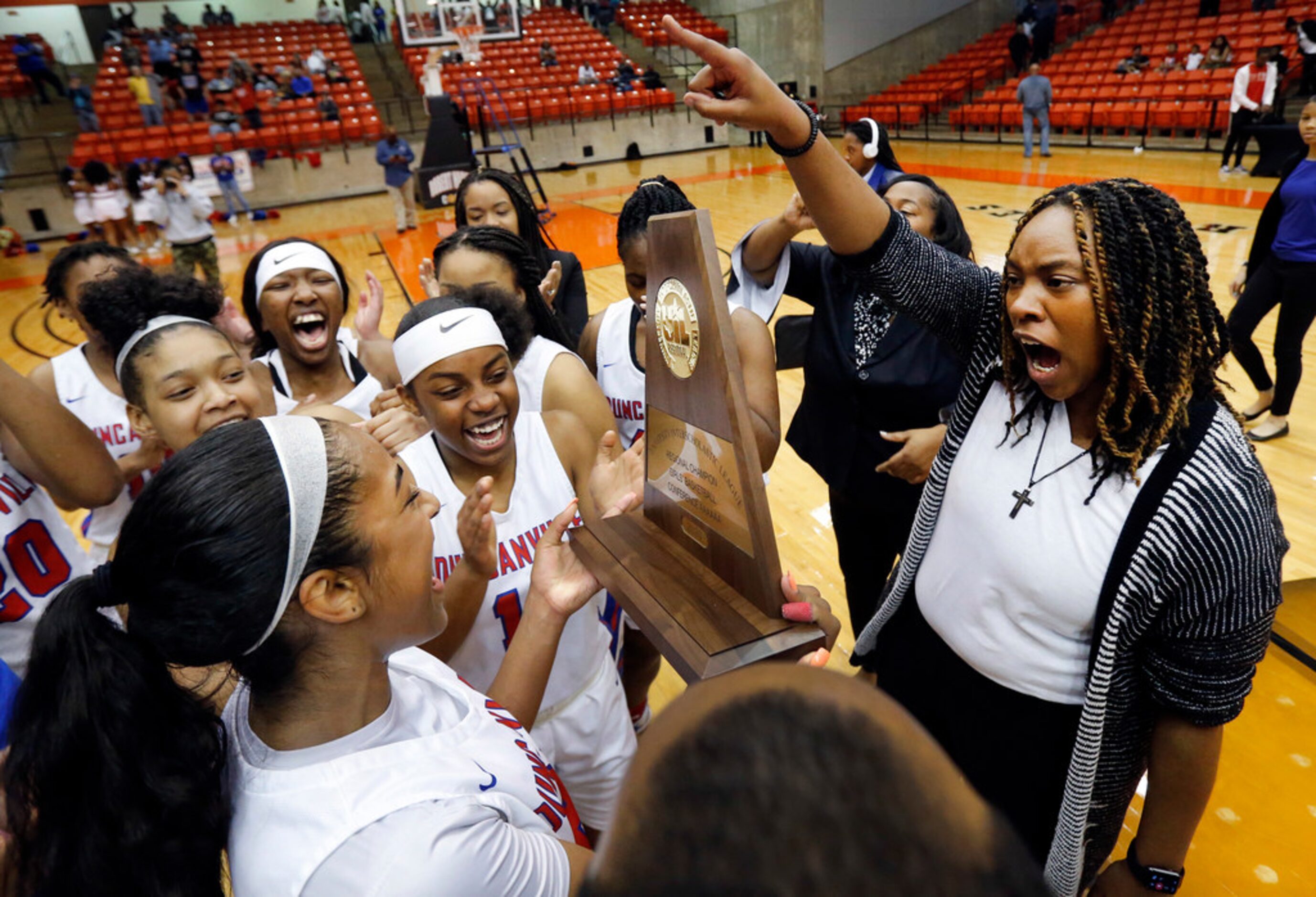 Duncanville's head coach Lajeanna Howard (right) and her players celebrate their Class 6A...