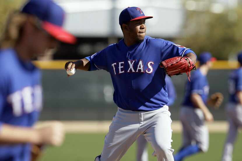 Texas Rangers' Neftali Feliz throws to first as pitchers participate in fielding drills...
