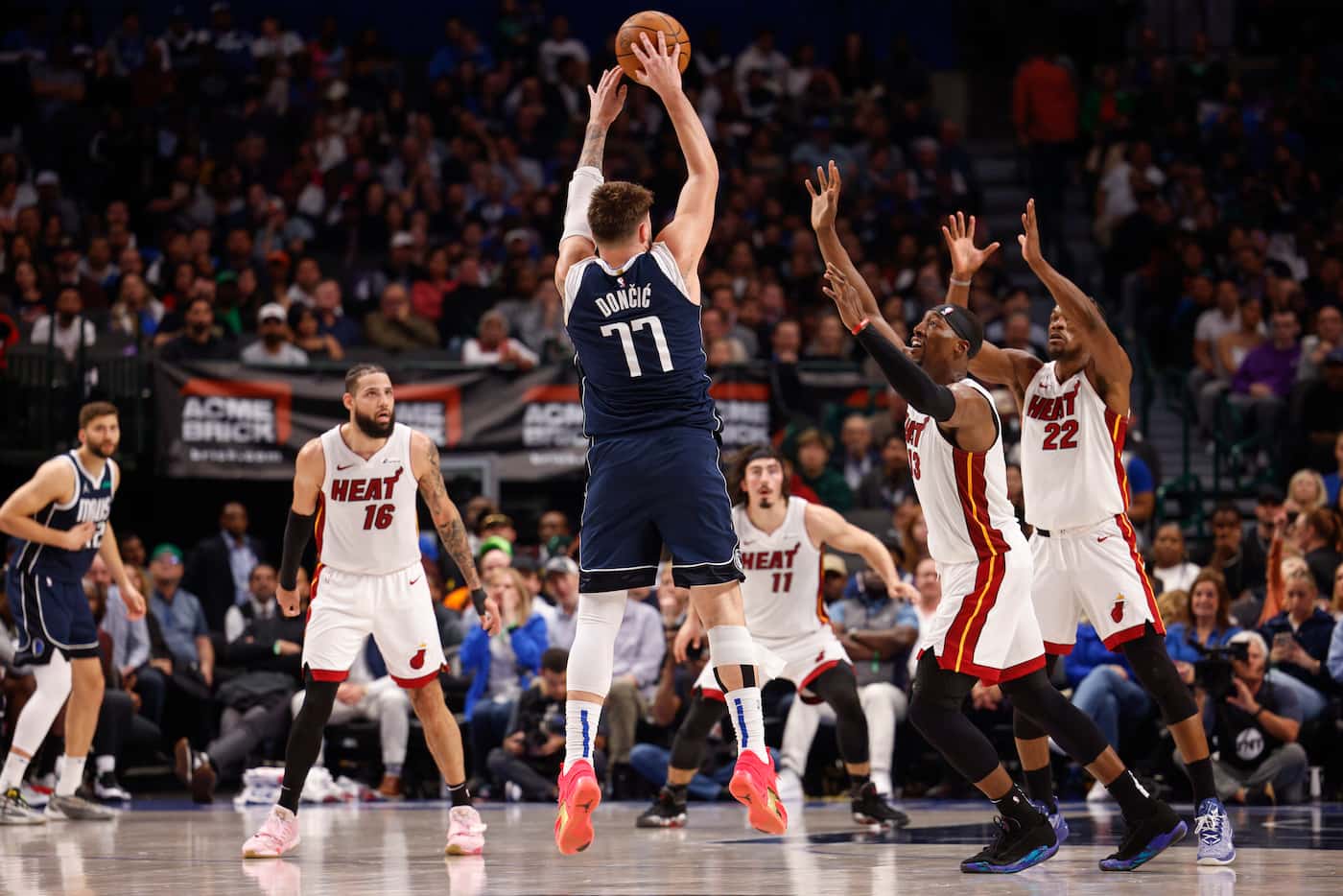 Dallas Mavericks guard Luka Doncic (77) shoots over Miami Heat center Bam Adebayo (13) and...