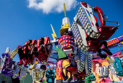 Shyanne Reynolds, 15, and Jersey Proctor, 12, ride a carnival ride on the midway at the...