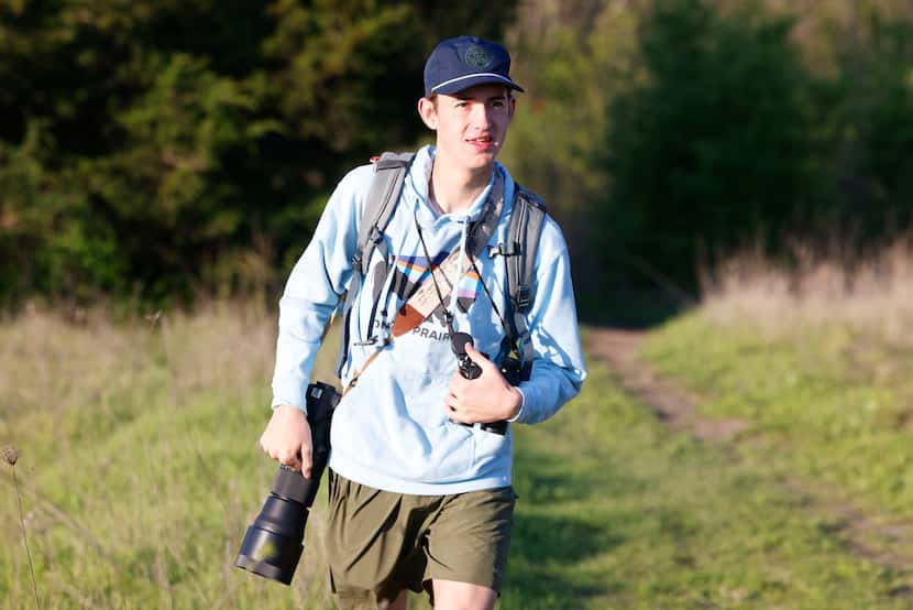Birdwatcher Kalder Korte, walks up a trail as he scouts for birds around Harry S Moss Park,...