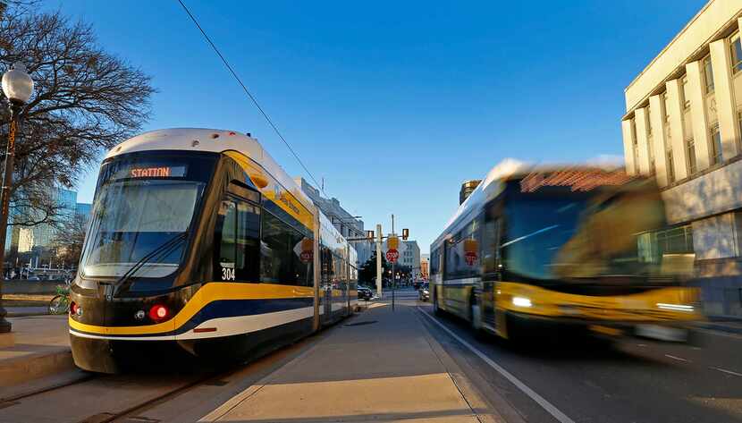 A DART bus passes by the Dallas Streetcar at the Reunion Station stop in Dallas, Tuesday,...