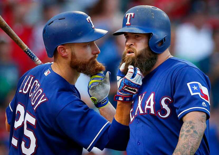 Texas Rangers Mike Napoli (right) and teammate Jonathan Lucroy (25) pull on each others...