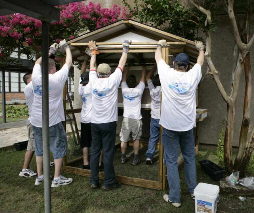 Volunteers from Citi Group raise the roof on a new chicken coop at Pershing Elementary.