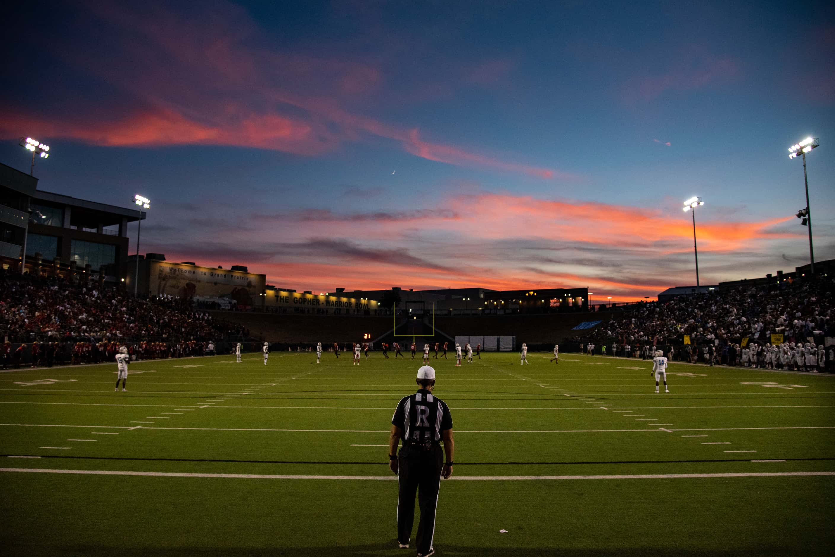 A referee stands in the end zone as the sun sets before South Grand Prairie kicks the ball...