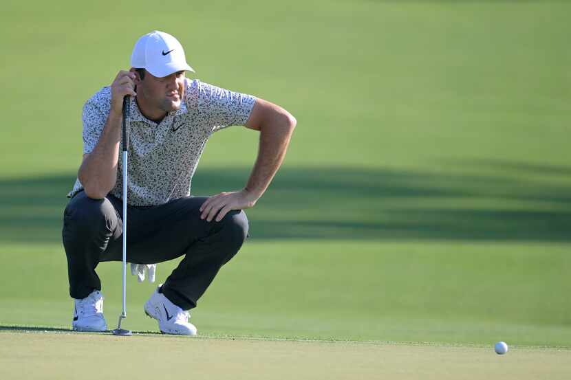 Scottie Scheffler lines up a putt on the 15th green during the first round of the Arnold...