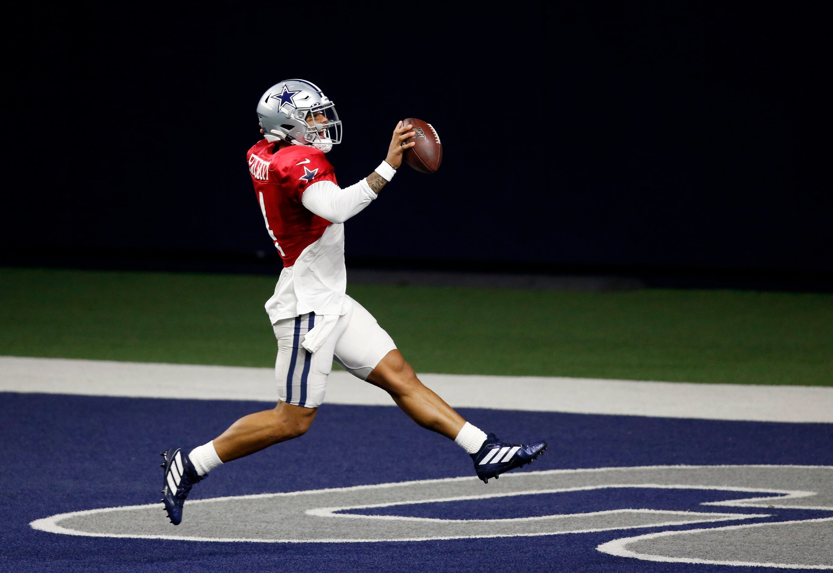 Dallas Cowboys quarterback Dak Prescott (4) high steps into the end zone during training...