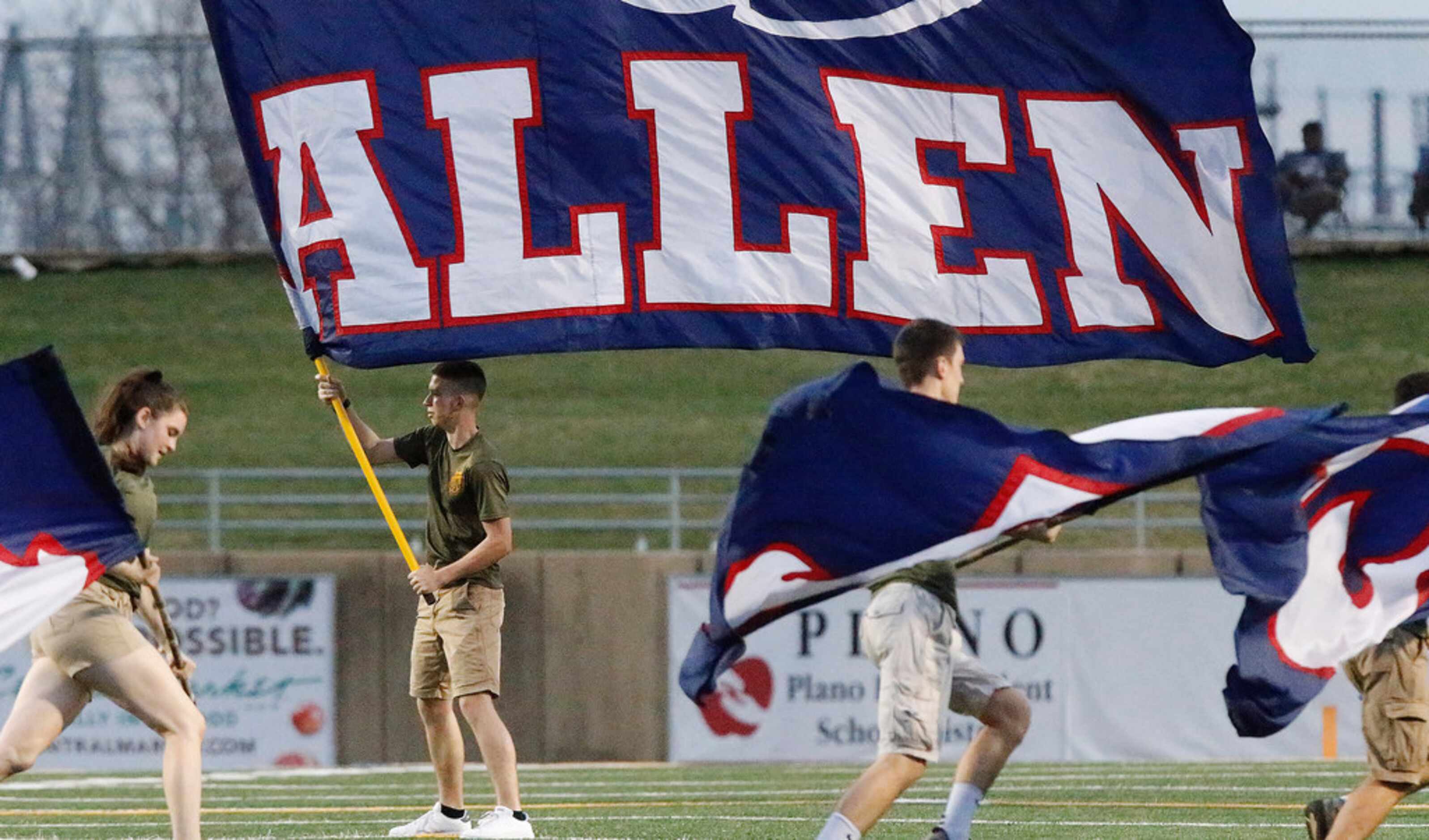 Aidan McGlothlin, 16, with the Allen High School Marine Core JROTC waves an Allen flag after...