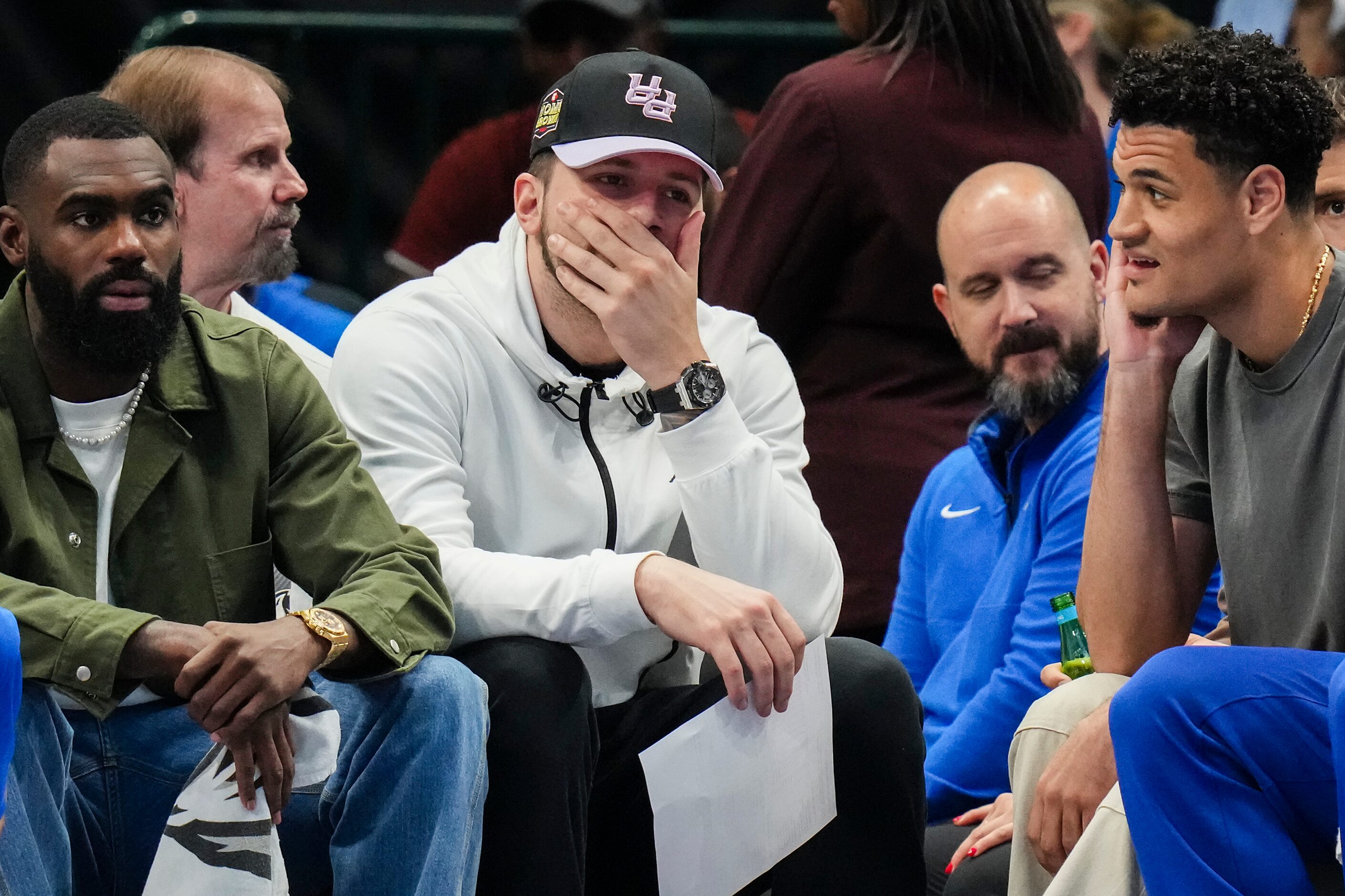 Dallas Mavericks guard Luka Doncic (center) watches from the bench with forward Tim Hardaway...