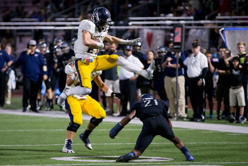 Highland Park Scots Jack Kozmetsky (21) leaps overs a tackle by Wylie East Raiders Kendrick...