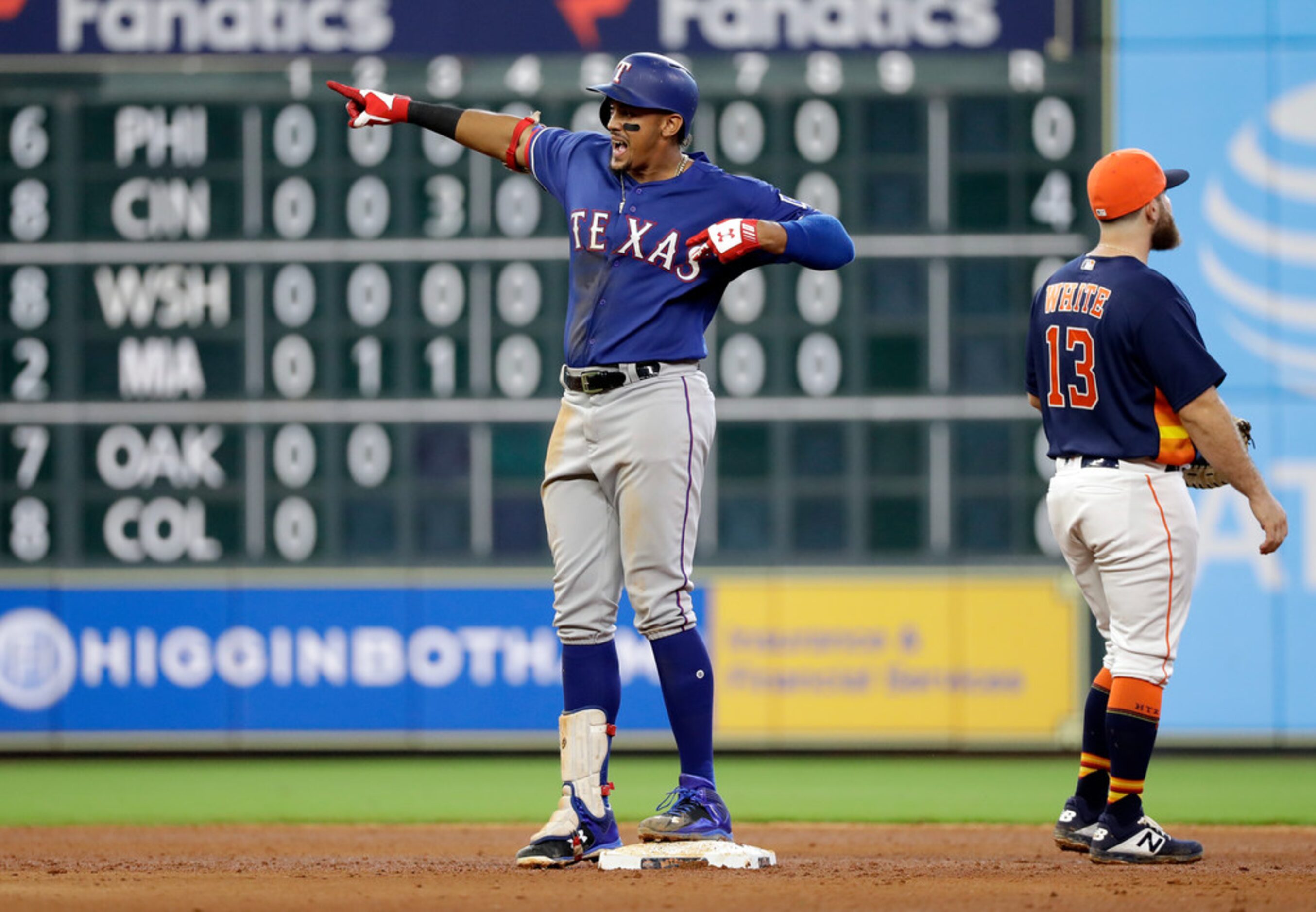 Texas Rangers' Ronald Guzman, left, reacts after hitting an RBI double as Houston Astros'...