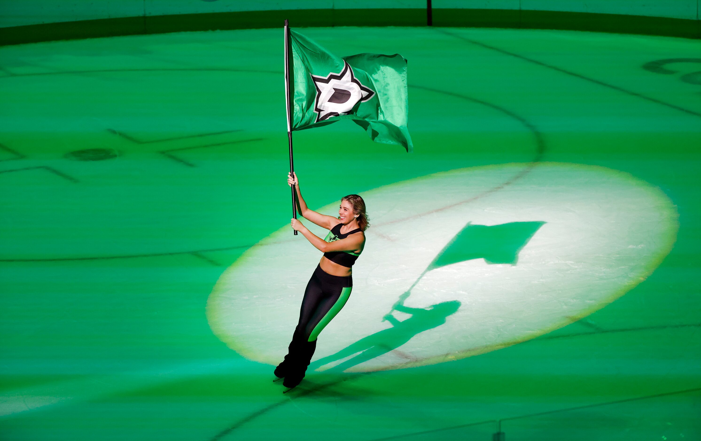 A Dallas Stars Ice Girl twirls the team flag following their regular season finale,1-0,...