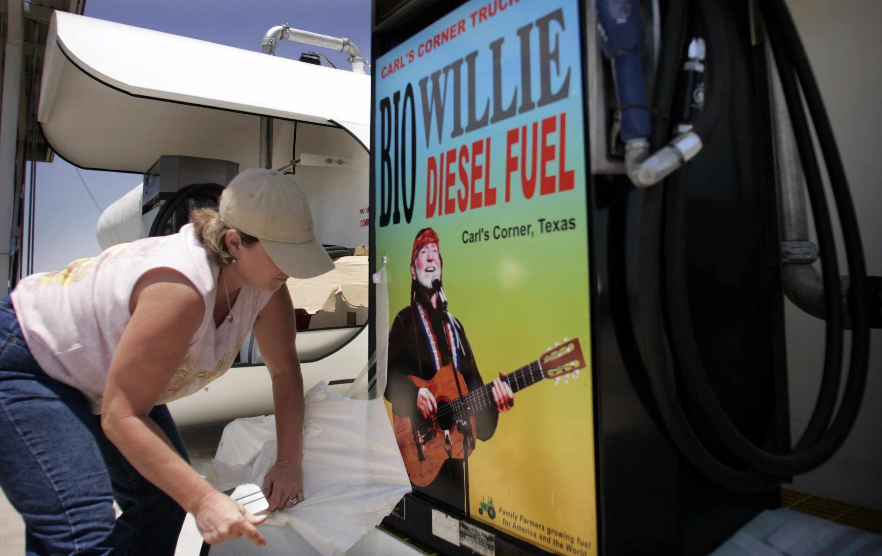 2005 - Carla Clapper adheres a new sign to a fuel tank holding BioWillie diesel fuel at...