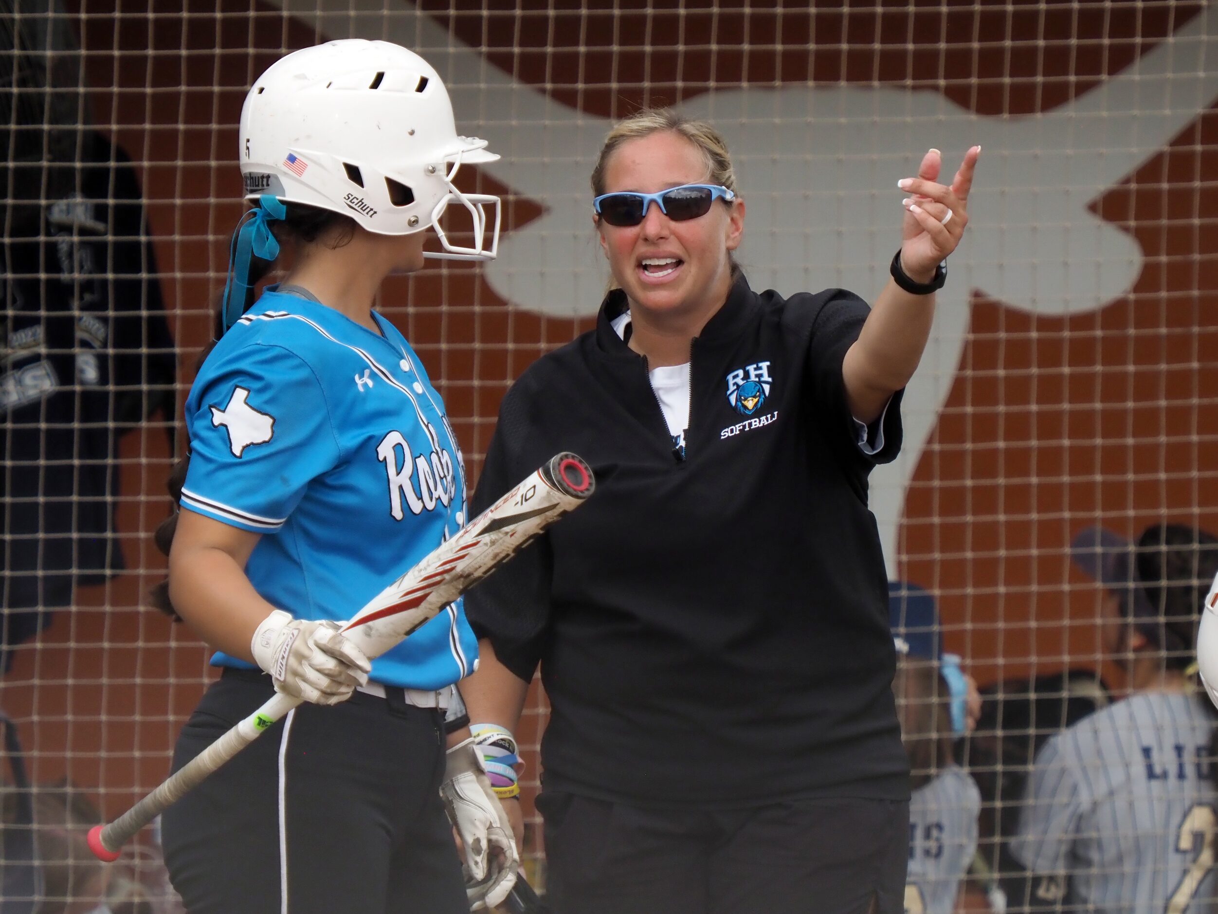 Prosper Rock Hill head coach Leigh Anne Budd (center) talks to batter Katerina Luna (left)...