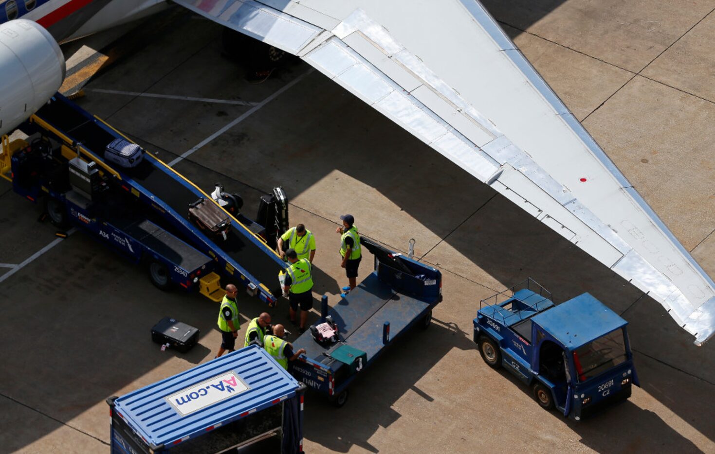 Members of the ground crew load bags onto an American Airlines jet at DFW International...