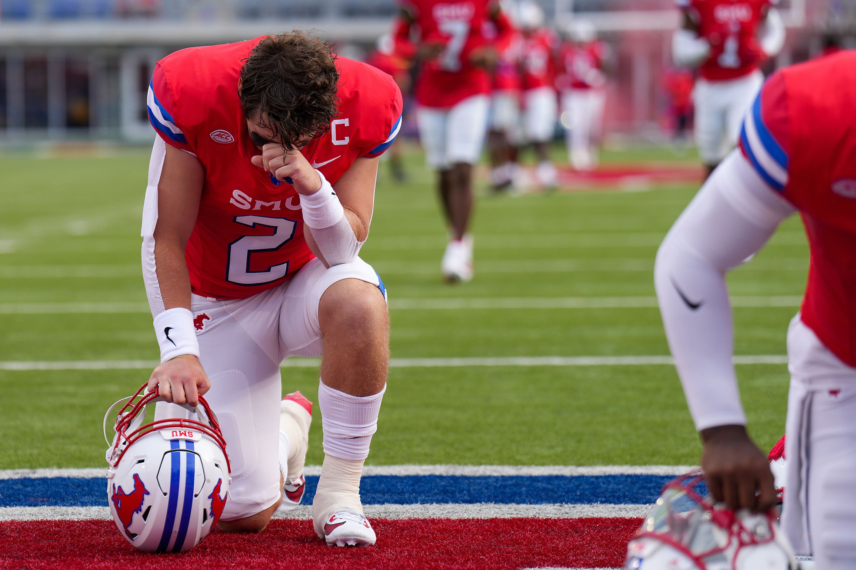 SMU quarterback Preston Stone (2) kneels in prayer before an NCAA football game against BYU...