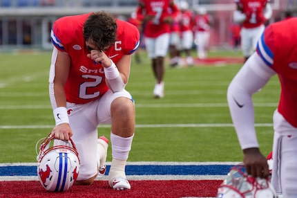 SMU quarterback Preston Stone (2) kneels in prayer before an NCAA football game against BYU...