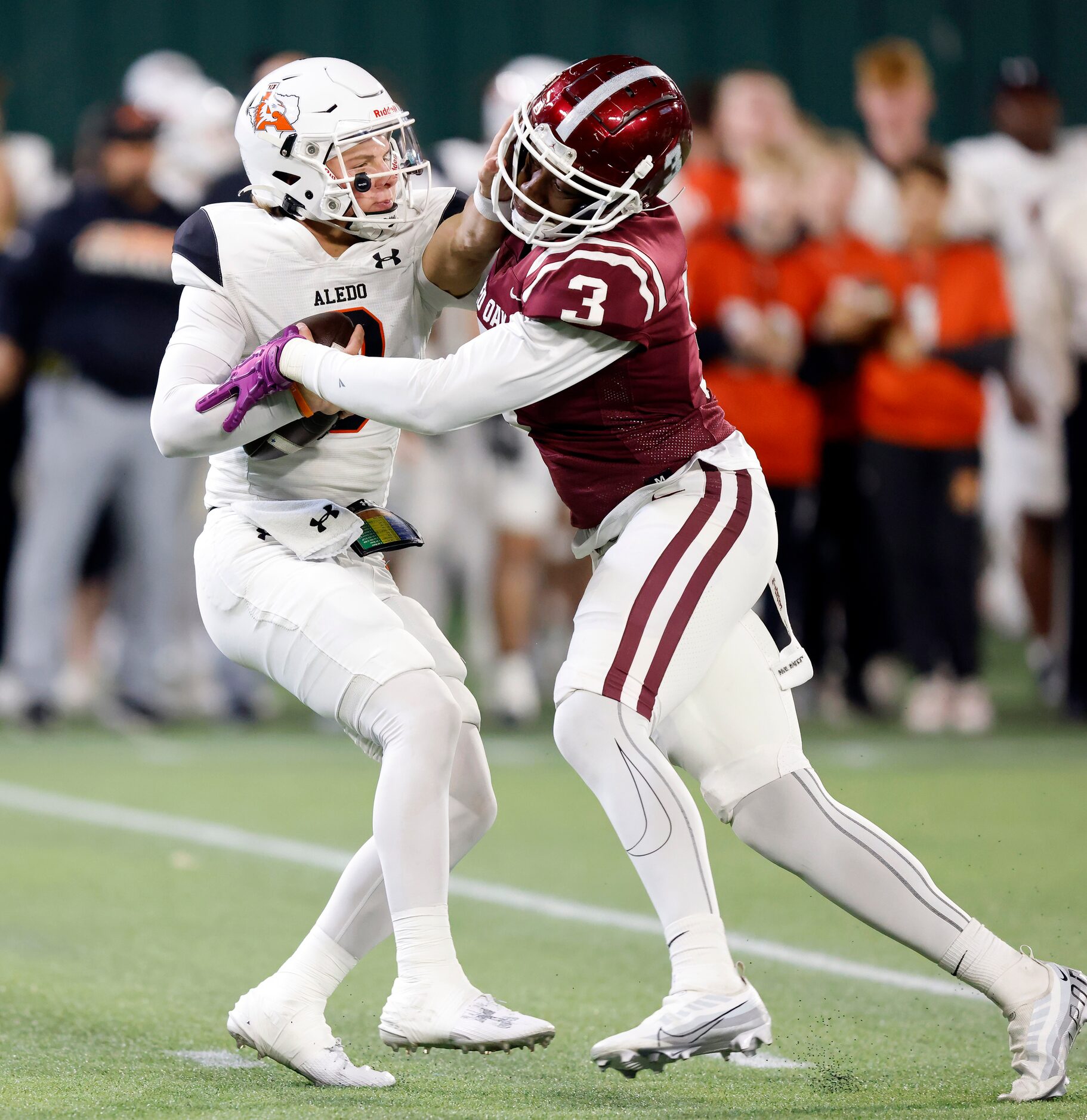 Aledo quarterback Hauss Hejny (8) is able to stiff arm his way past Red Oak defensive end...