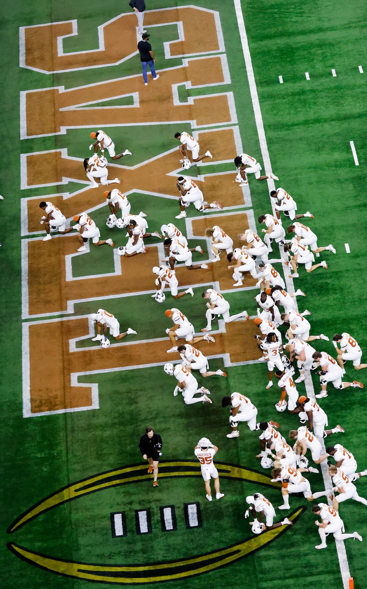 Texas Longhorns football players take a knee in the end zone as they were introdiuced before...