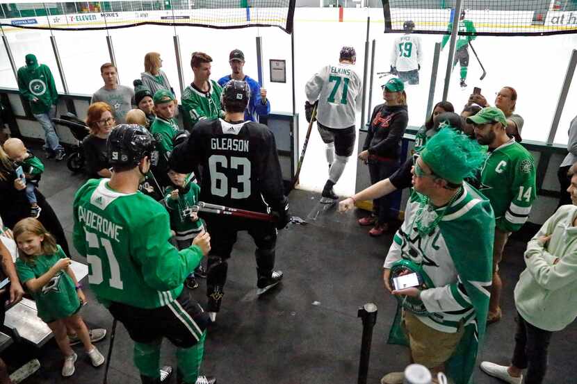 Dallas Stars players go through some of the fans on hand to take the ice for their third...