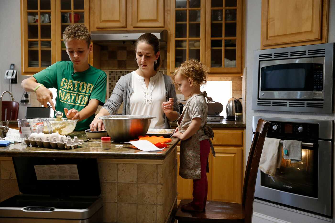 Brian, Laura and Sariah Ellis work on making snickerdoodles at their Frisco home. Brian...