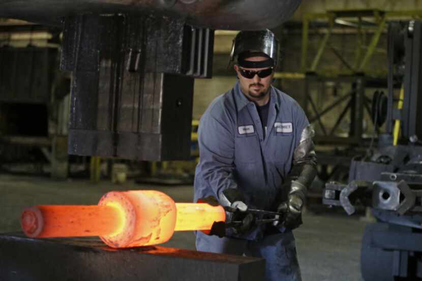 Jack Knox positions a hot spindle being shaped at Solmet Technologies in Canton, Ohio. The...