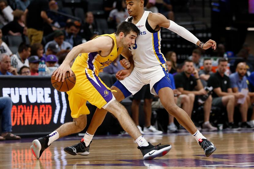 Golden State Warriors guard Jordan Poole, right, blocks the drive of Los Angeles Lakers...