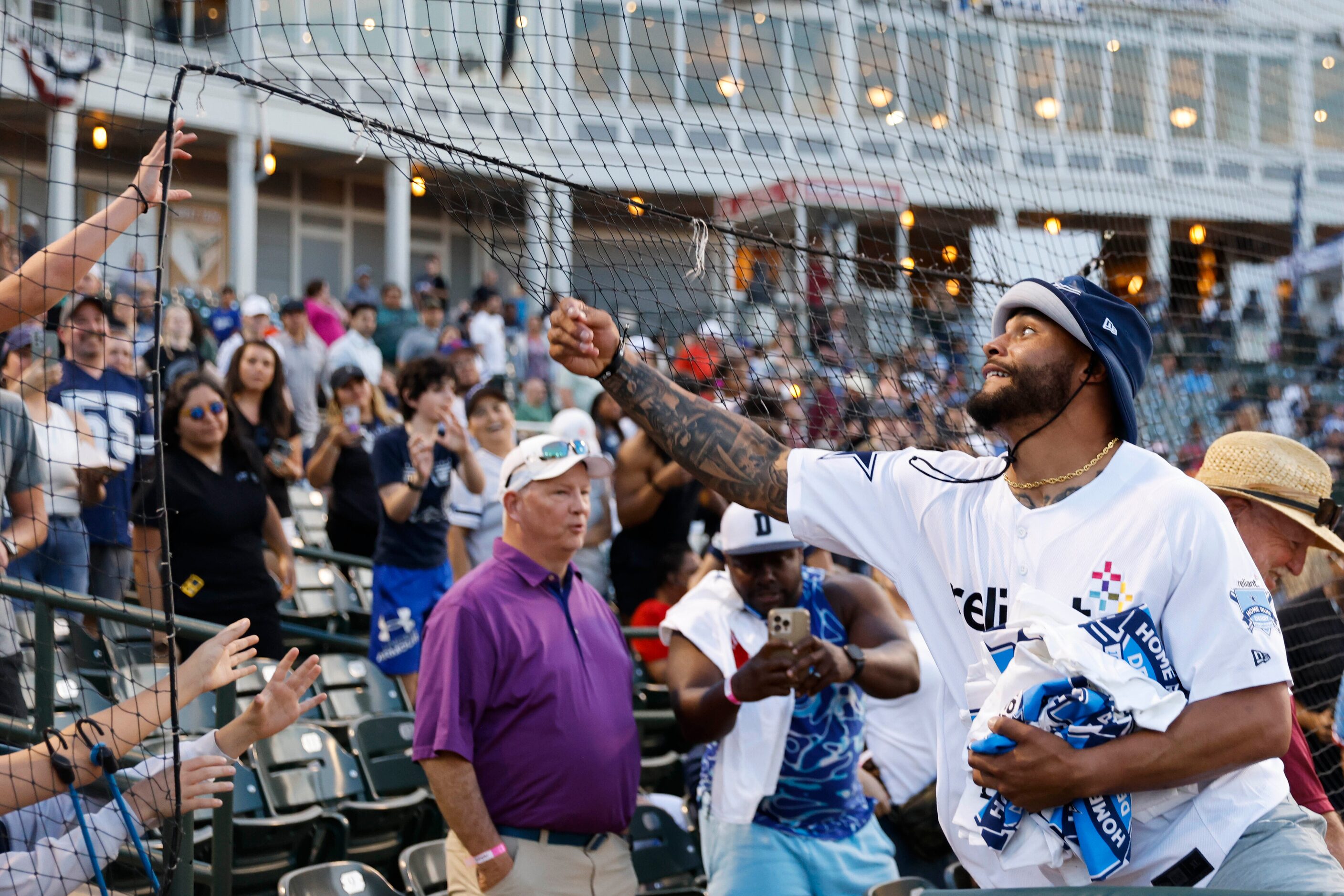 Dallas Cowboys QB Dak Prescott gives t-shirts to fans during the annual home run derby on...