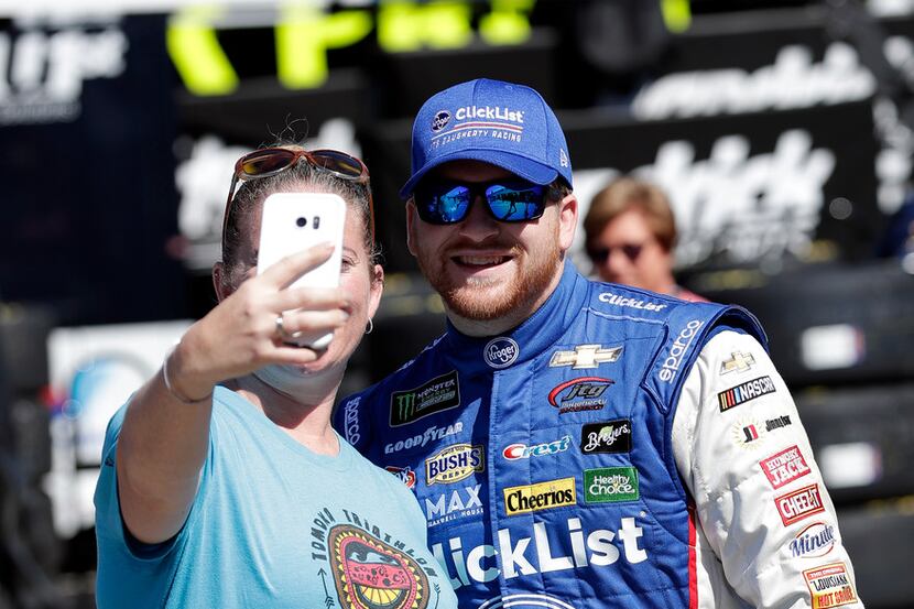 Chris Buescher, right, poses with a fan for a photo in the garage area before practice for...