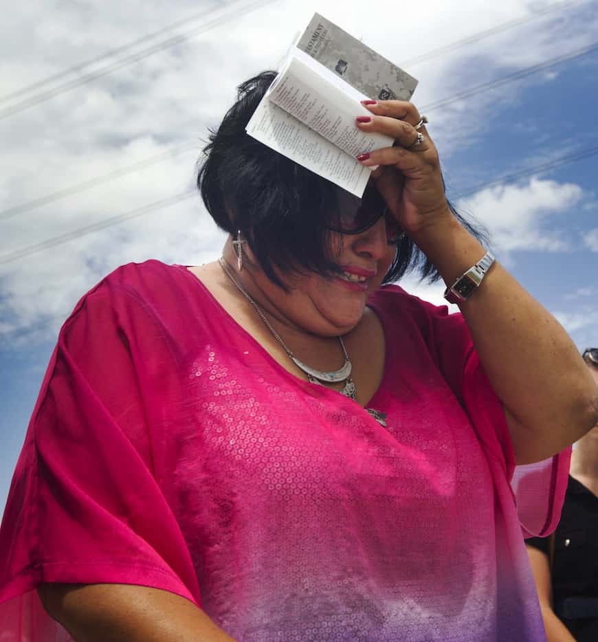 Nixon resident, Lisa Peralez reads a prayer at the site of Saturday's hot air balloon crash...