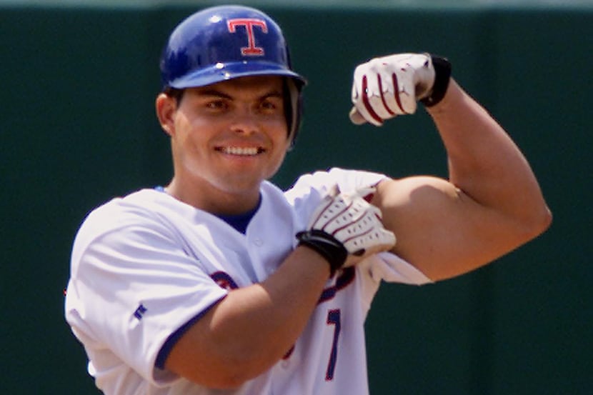 Texas Rangers catcher Ivan Rodriguez shows off his bicep from second base after hitting a...