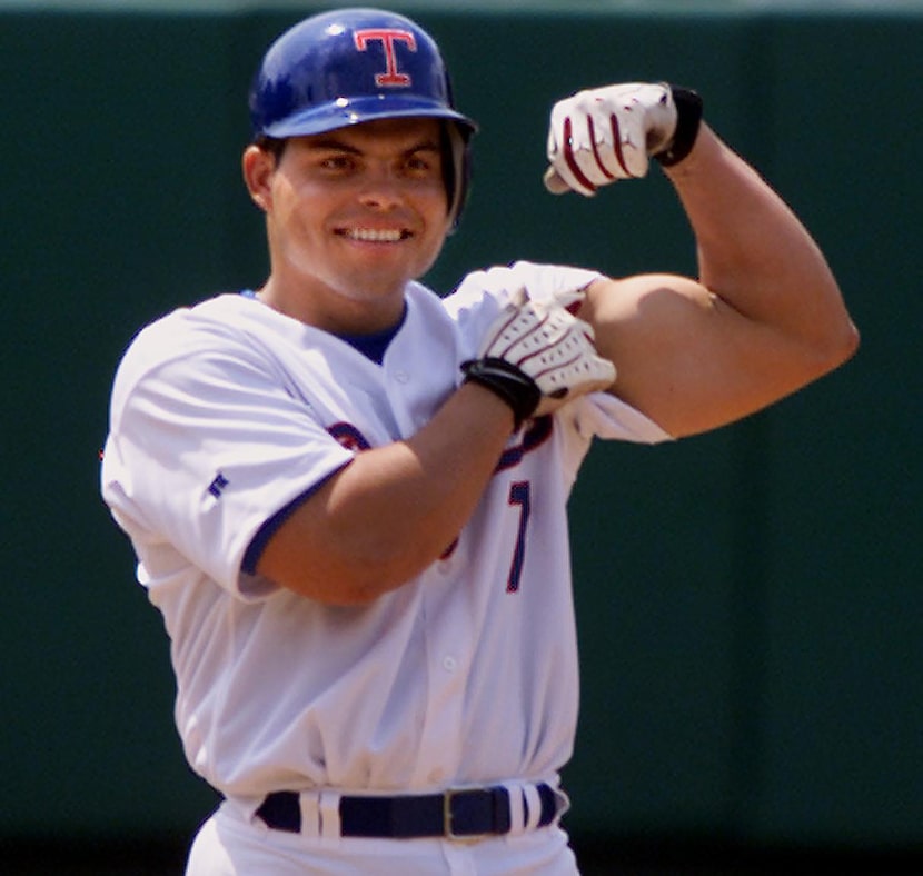 Texas Rangers catcher Ivan Rodriguez shows off his bicep from second base after hitting a...