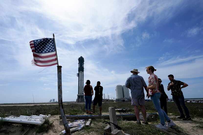 Onlookers watch as SpaceX's Starship, the world's biggest and most powerful rocket, stands...