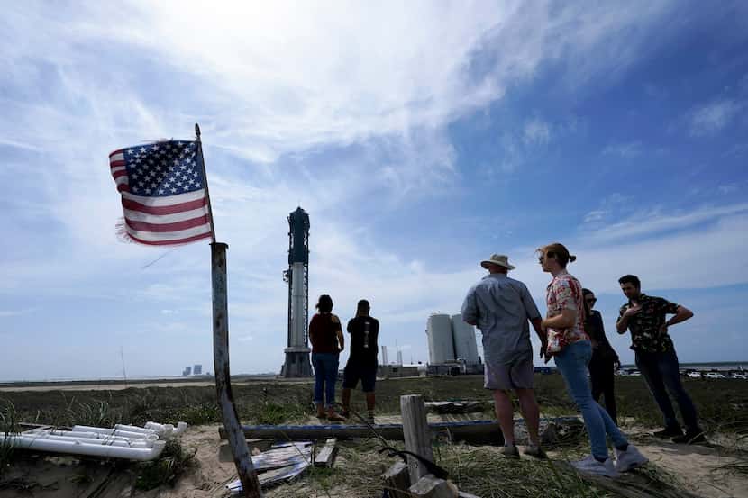 Onlookers watch as SpaceX's Starship, the world's biggest and most powerful rocket, stands...
