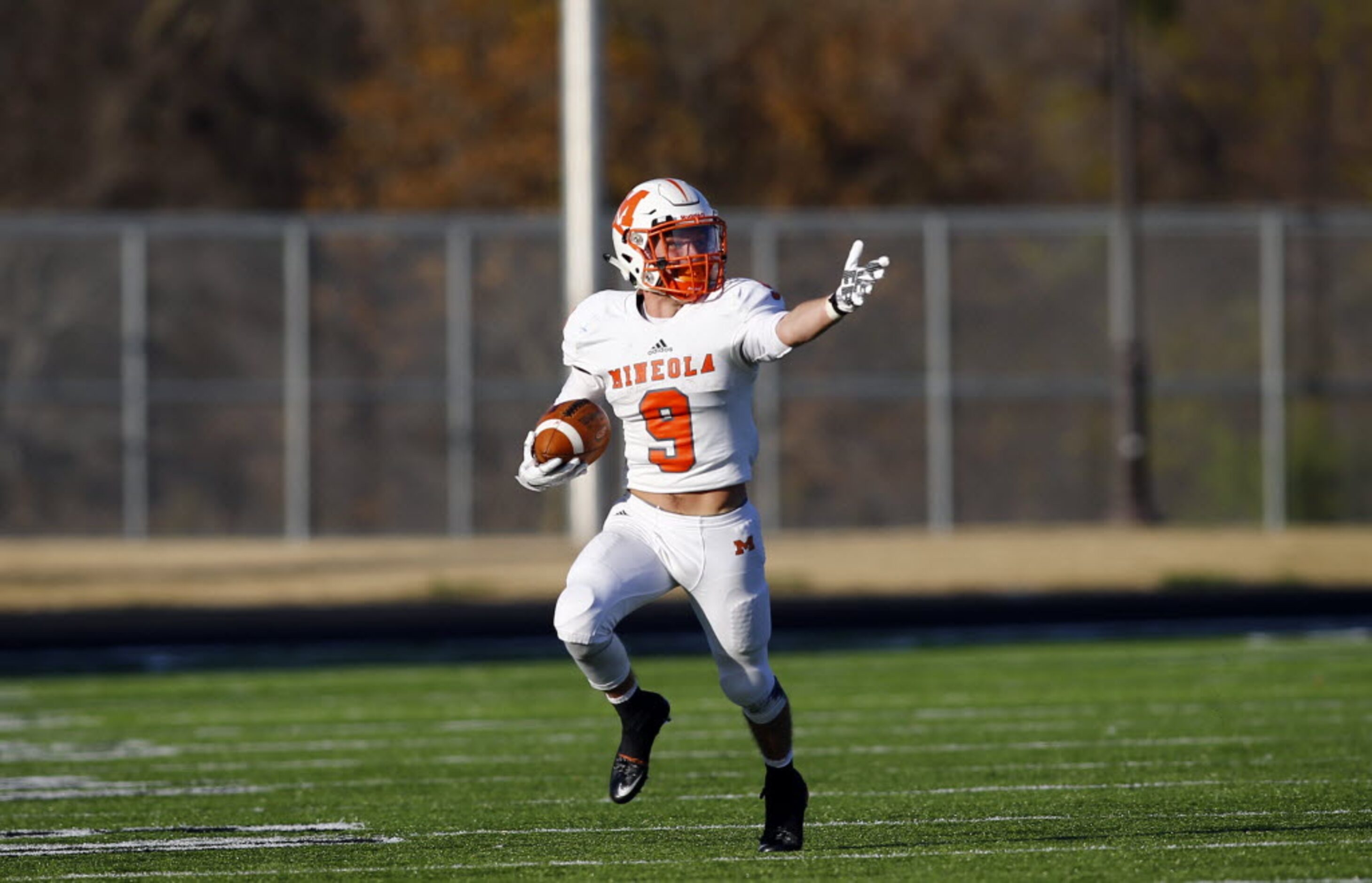 TXHSFB Mineola's Chantz Perkins (9) gestures down field as he carries the ball in their...