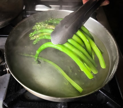 You can tell poached asparagus has cooked long enough when the spears droop at either end...