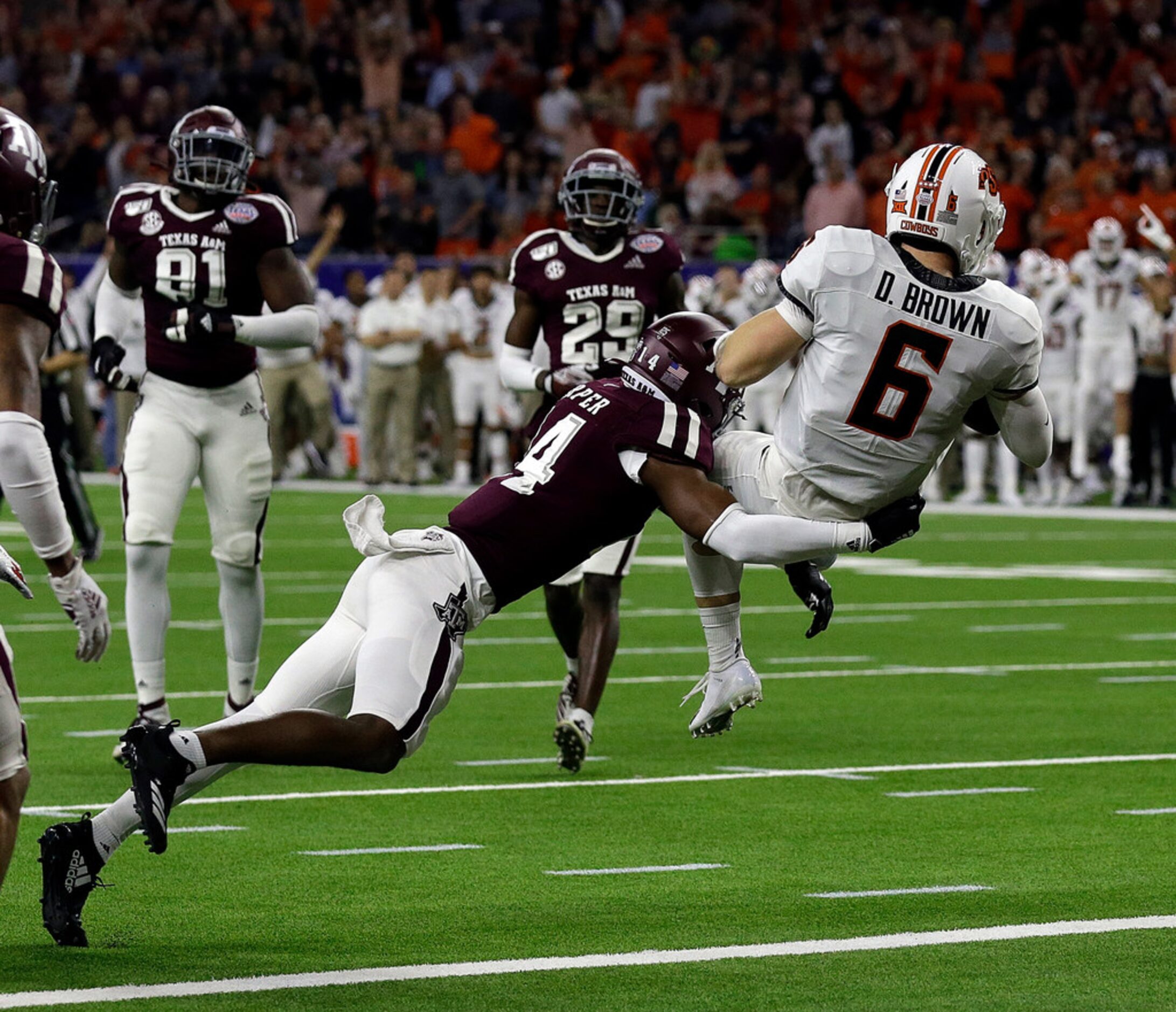 HOUSTON, TEXAS - DECEMBER 27: Dru Brown #6 of the Oklahoma State Cowboys scores on a nine...