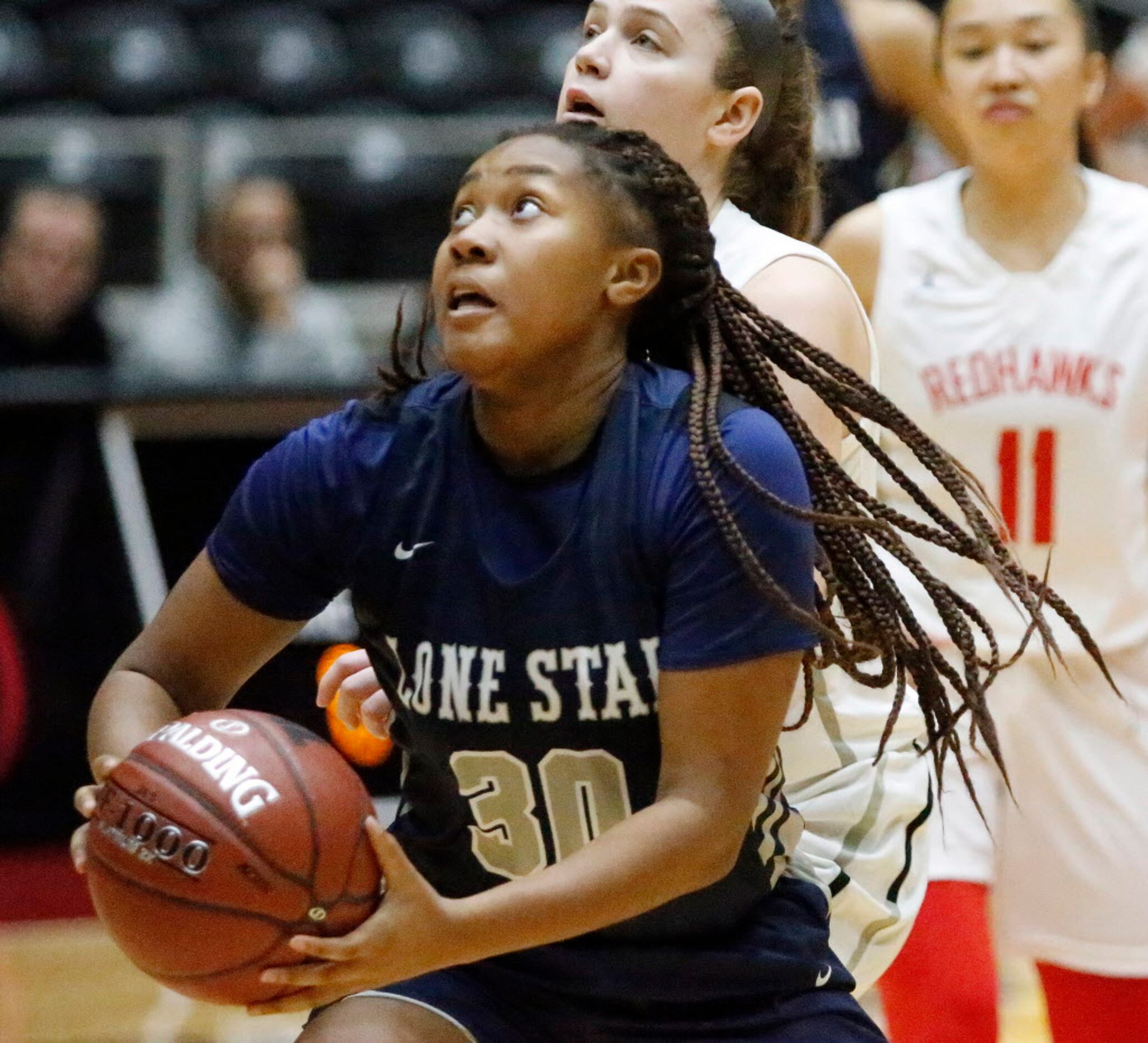 Lone Star High School forward Kayla Richardson (30) goes in for a basket during the first...