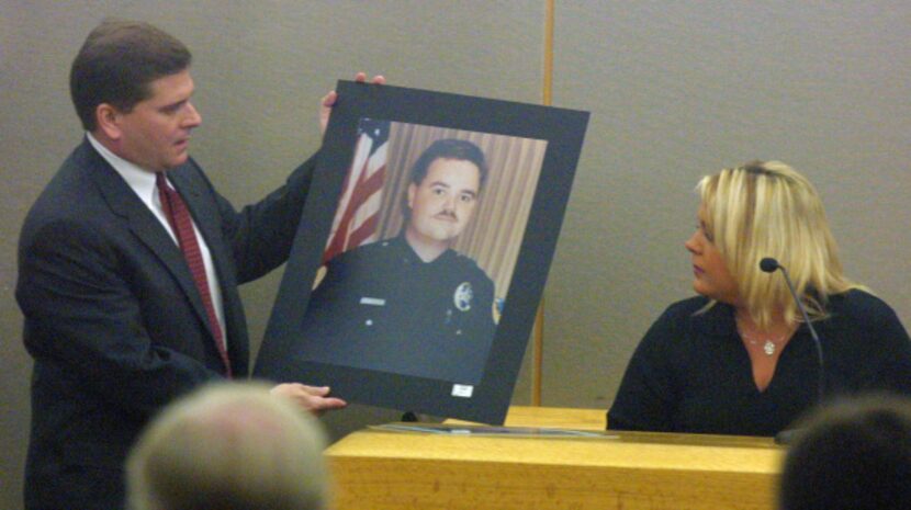 In court, Lori Hawkins (right) identified a picture of her slain husband held by Toby Shook....