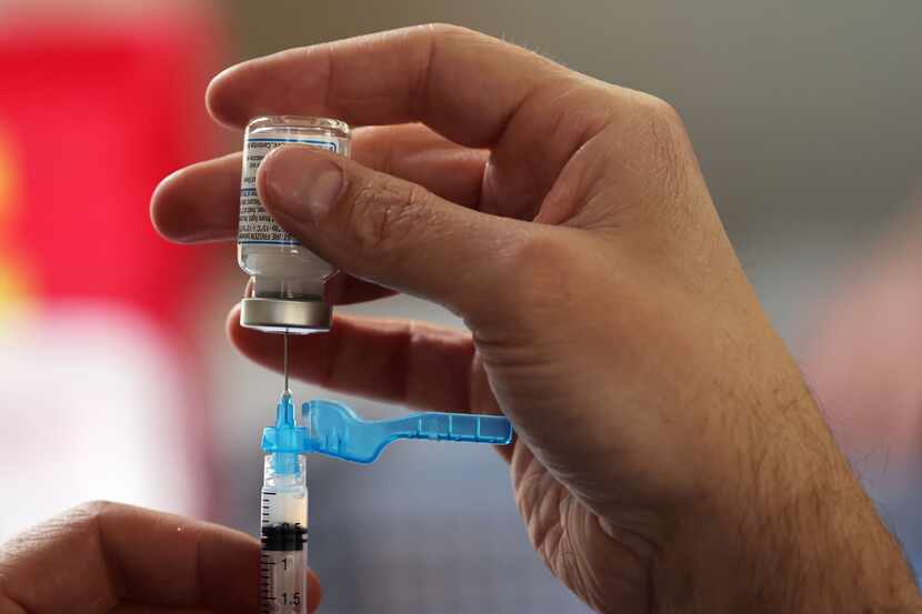 Staff pulled doses of the Moderna COVID-19 vaccine at a drive-through vaccination clinic at...
