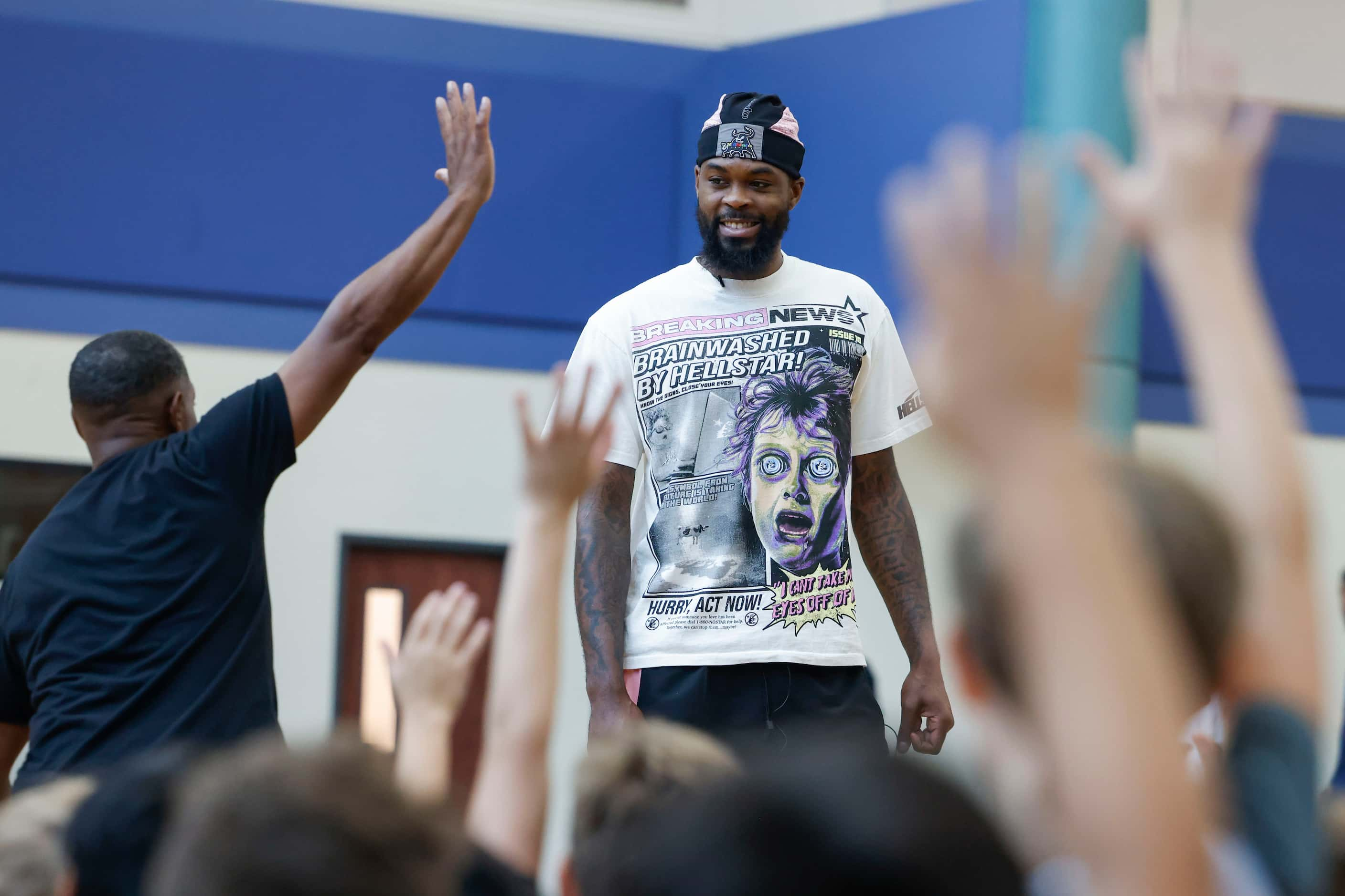 Dallas Mavericks’ Naji Marshall, looks to take questions from the young basketball campers...