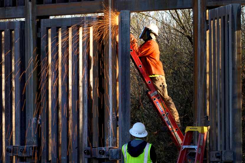Crews construct a section of border wall in San Bernardino National Wildlife Refuge,...