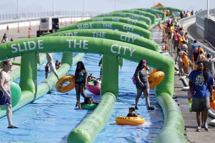 Water sliders slide down a 1,000 foot water slide and walk back to the top during the Slide...
