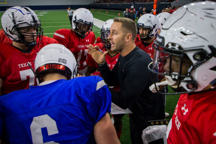 The Texas Tech offense huddles around head coach Kliff Kingsbury during the Red Raiders'...