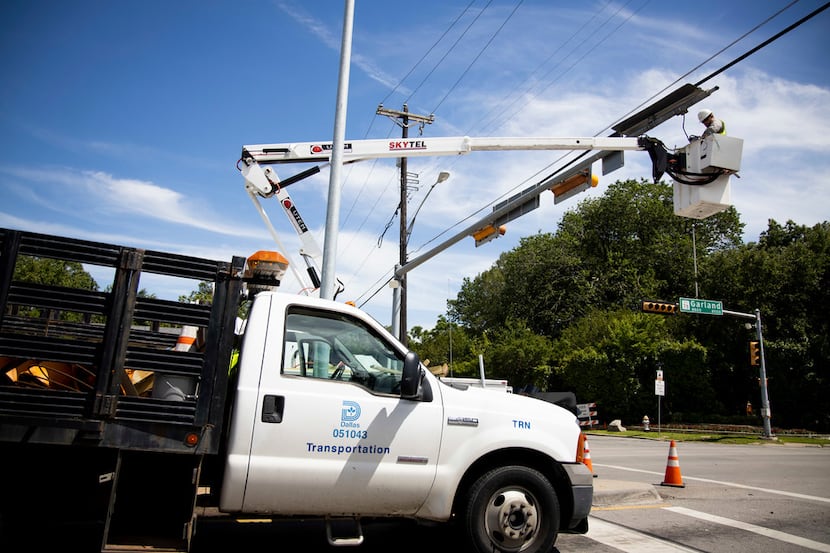 A city of Dallas employee works on traffic lights near the Dallas Arboretum on Monday....