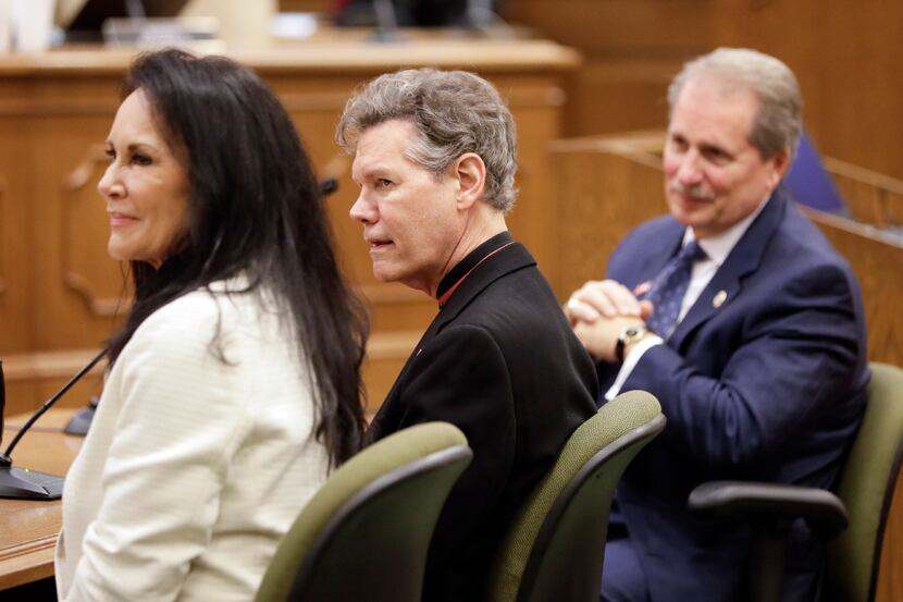 Country singer Randy Travis, center, and his wife, Mary, left, attend a meeting of the...