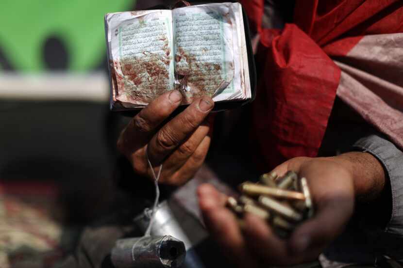 An Egyptian supporter of deposed president Mohamed Morsi holds a bloodstained copy of the...