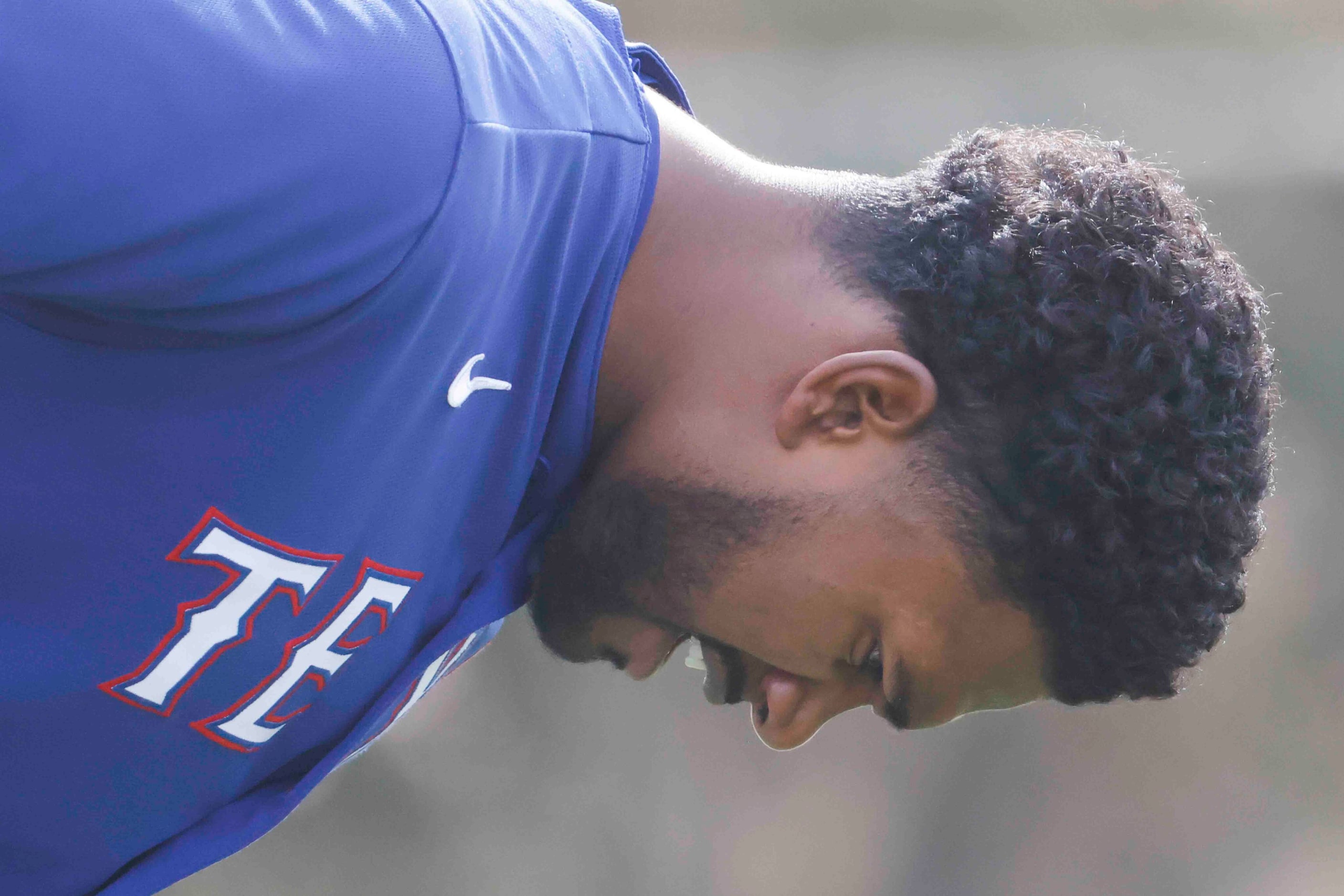 Texas Ranger pitcher Kumar Rocker takes a breather between running laps during a spring...